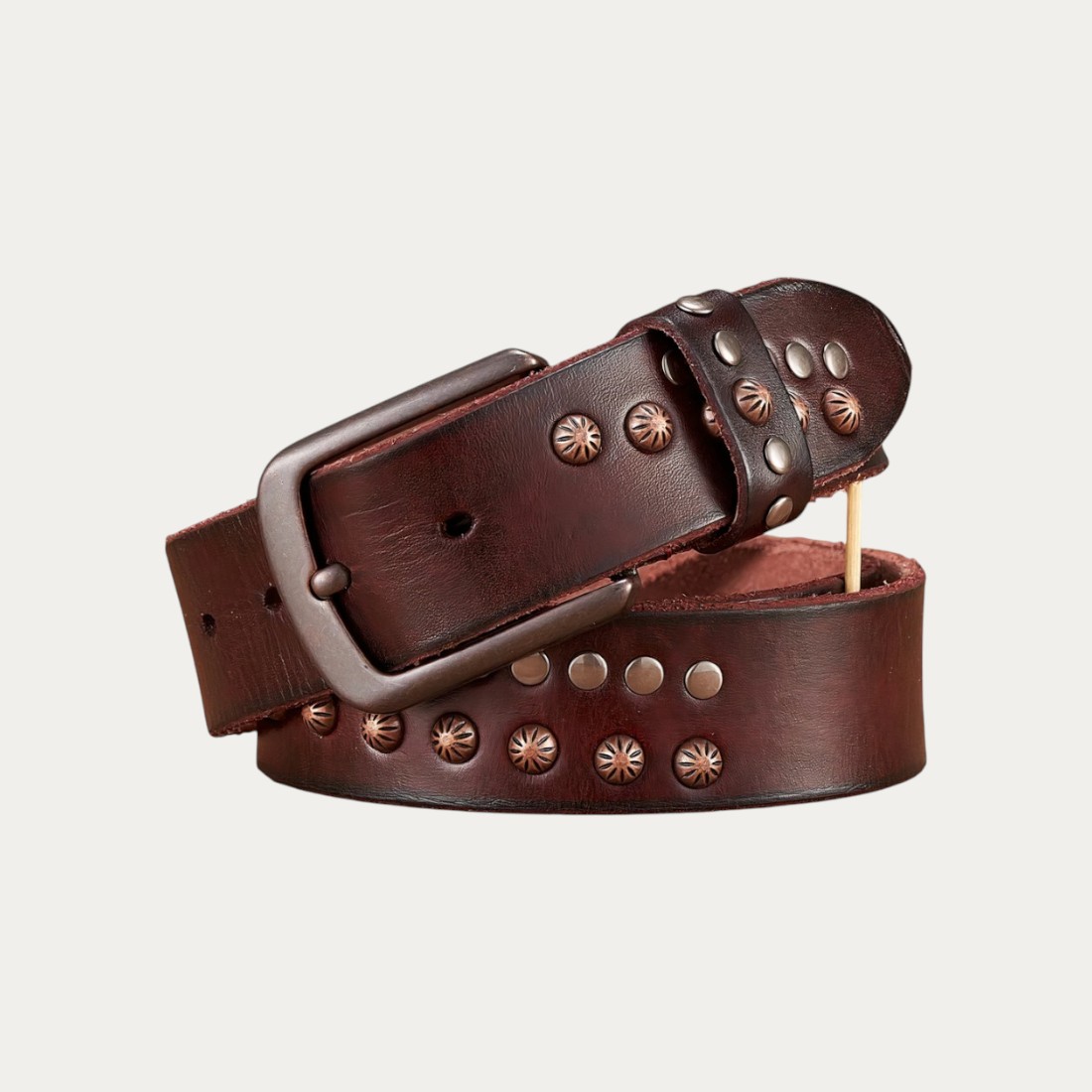 Ceinture western homme en cuir riveté marron sur fond uni.
