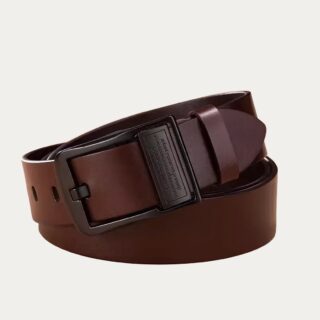 Ceinture élégante pour homme en cuir fendu marron et boucle noire discrète enroulée sur elle, sur fond uni.