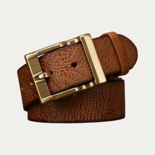 Ceinture inspiration crocodile homme camel avec sa boucle en laiton enroulée sur elle sur fond uni.