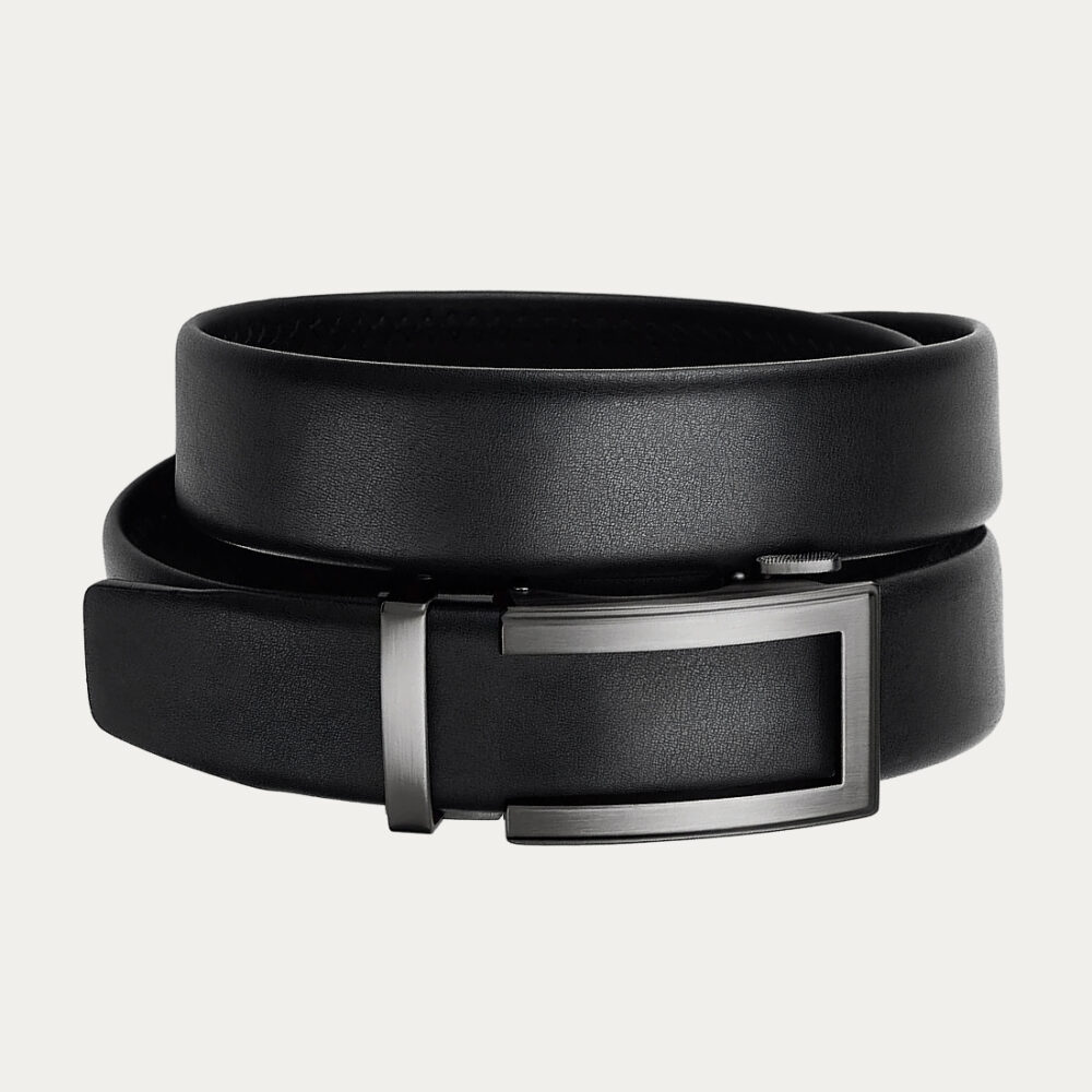 Une ceinture homme mariage à boucle automatique design moderne noire enroulée sur elle-même sur un fond gris très clair uni.