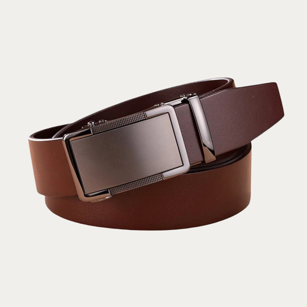 Une ceinture homme mariage à boucle plaque automatique dont le cuir est marron, enroulée sur elle-même sur un fond gris très clair uni.