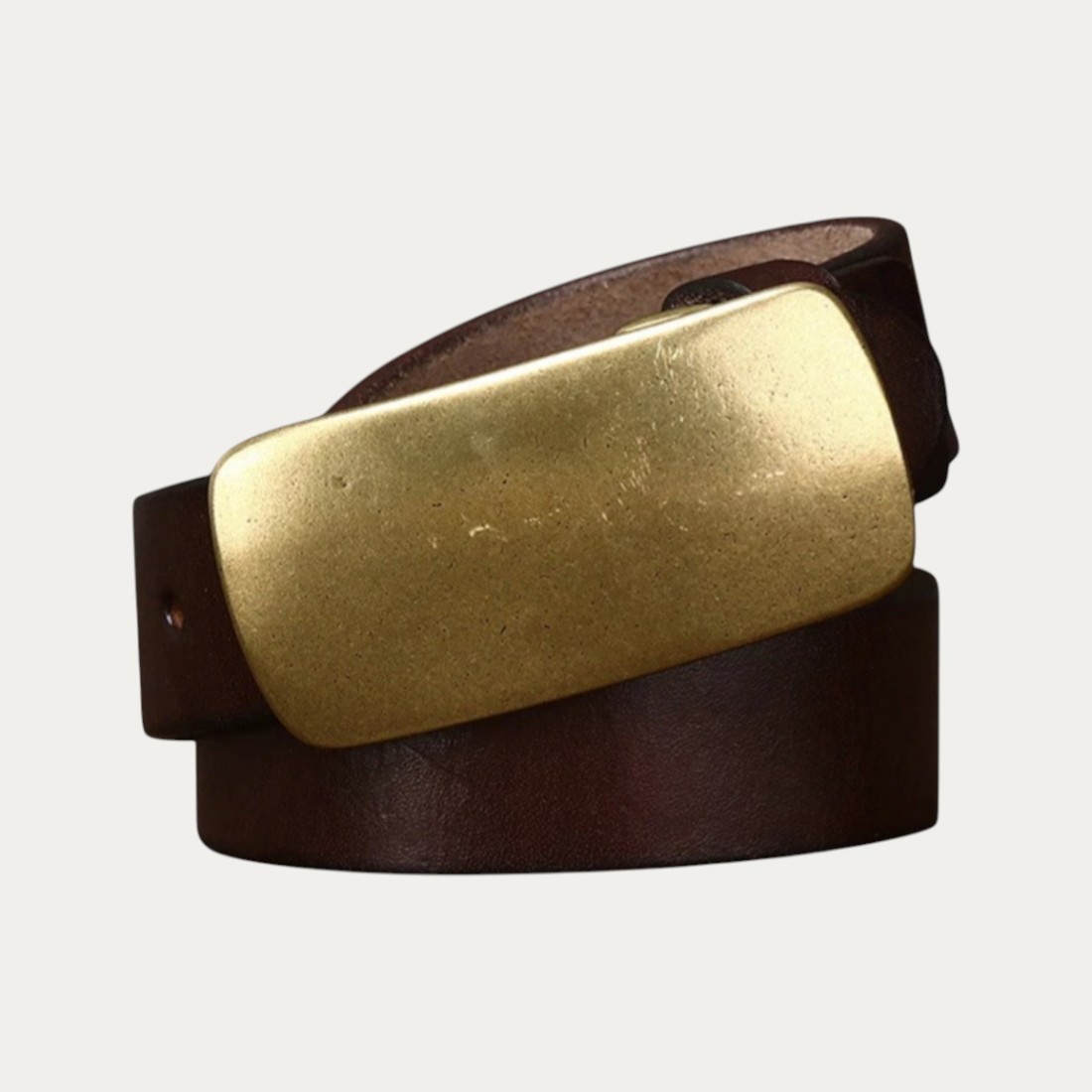 Ceinture homme en cuir pleine fleur avec boucle plaque en cuivre patiné rectangulaires sur fond uni.