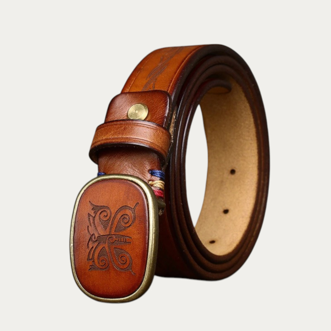 Ceinture plaque homme en cuir gravé marron avec boucle ovale laiton vieilli, motif discret et finition artisanale, style masculin raffiné et intemporel.