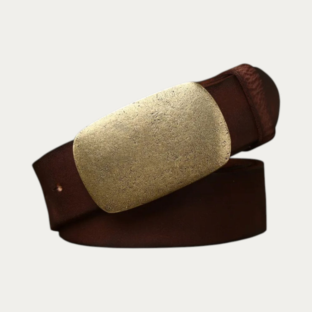 Ceinture plaque homm en cuire avec finition vieillie de couleur marron et boucle cuivré rectangulaire enroulée sur elle-même sur fond uni.